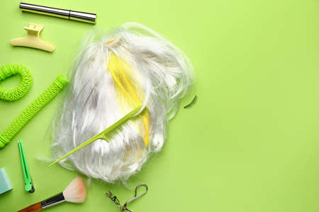 White wig and hairdresser tools on color backgroundの写真素材