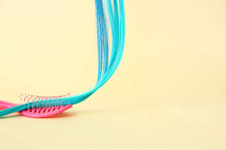 Blue hair strand and brush on color backgroundの写真素材