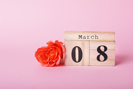 Calendar with date of International Women's Day and flower on color backgroundの写真素材