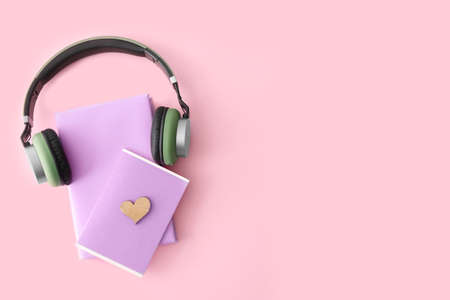 Books and modern headphones on color background. Concept of audiobookの写真素材
