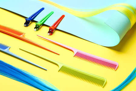 Paper, hair strand, clasp-pins and combs on color background