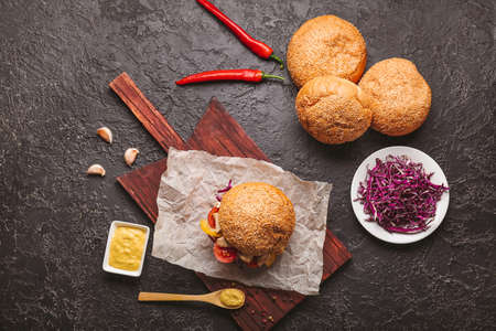 Tasty doner kebab in bun and sauce on dark background
