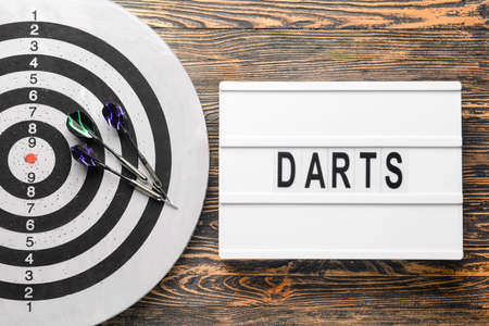 Dartboard with darts on wooden backgroundの写真素材