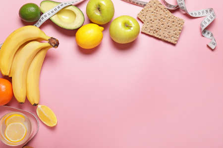 Different healthy food with measuring tape on color background. Diet conceptの写真素材