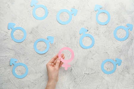 Female hand with symbols of woman and man on white background. Concept of feminismの写真素材