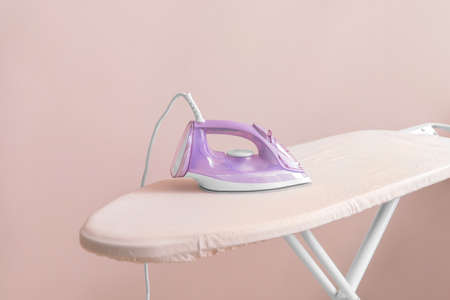 Electric iron and board on light backgroundの写真素材