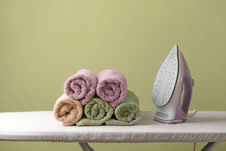 Electric iron and board on color backgroundの写真素材