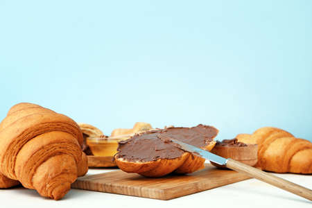 Tasty sweet croissants with chocolate on color backgroundの写真素材