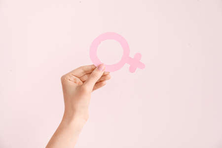 Female hand with symbol of woman on color background. Concept of feminismの写真素材