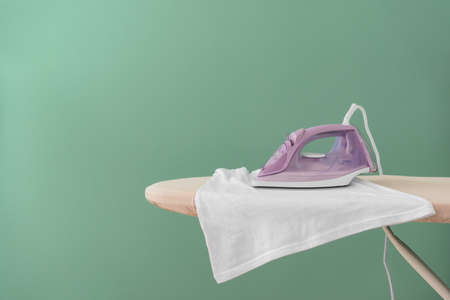 Electric iron and board on color backgroundの写真素材