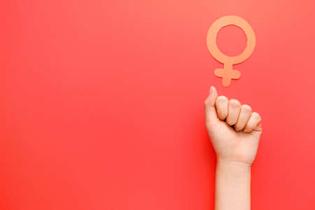 Female hand with symbol of woman on color background. Concept of feminismの写真素材