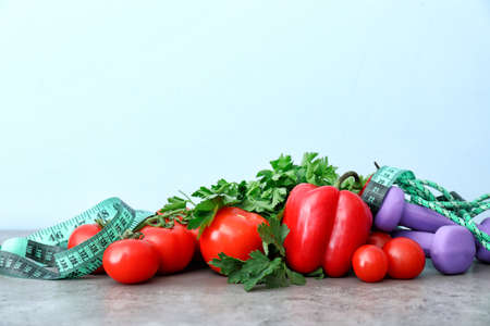 Different healthy food with measuring tape and sports equipment on table. Diet conceptの写真素材