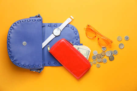 Purse with wallet, money and accessories on color backgroundの写真素材