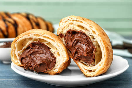 Plate with tasty sweet croissant on tableの写真素材