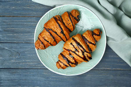 Plate with tasty sweet croissants on tableの写真素材