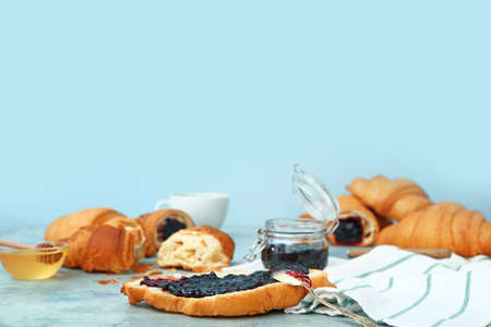 Tasty sweet croissants with jam on color backgroundの写真素材