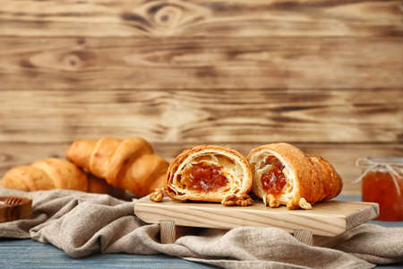 Tasty sweet croissant with jam on wooden tableの写真素材