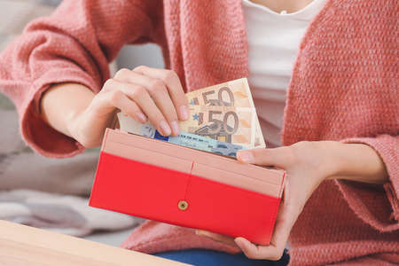 Young woman with money at home, closeupの写真素材