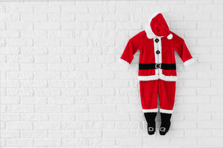 Santa Claus costume hanging on white brick wallの写真素材