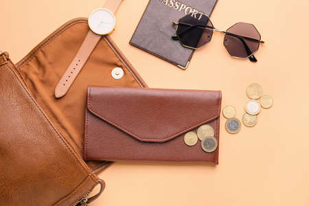 Purse with wallet, money, passport and accessories on color backgroundの写真素材