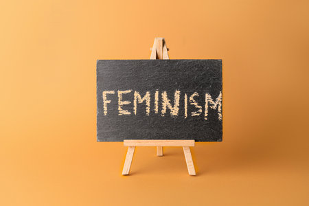 Chalkboard with written text FEMINISM on color backgroundの写真素材