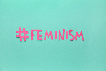 Paper word FEMINISM with hashtag on color backgroundの写真素材
