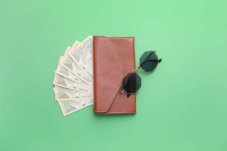 Wallet with money and sunglasses on color backgroundの写真素材