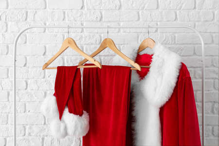 Hanger with Santa Claus costume near brick wallの写真素材