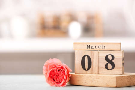 Calendar with date of International Women's Day and flower on table in kitchenの写真素材