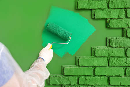 Male worker painting wall in roomの写真素材