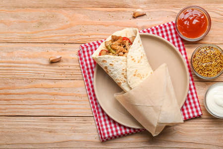 Tasty doner kebab and sauces on wooden backgroundの写真素材