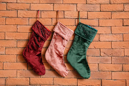 Different Christmas socks hanging on brick wallの写真素材