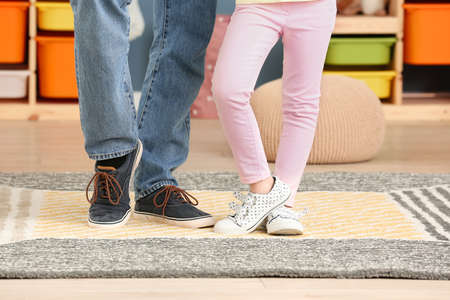 Legs of father and his little daughter dancing at homeの写真素材