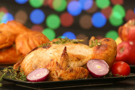 Tasty baked turkey for Thanksgiving day on table against blurred lightsの写真素材