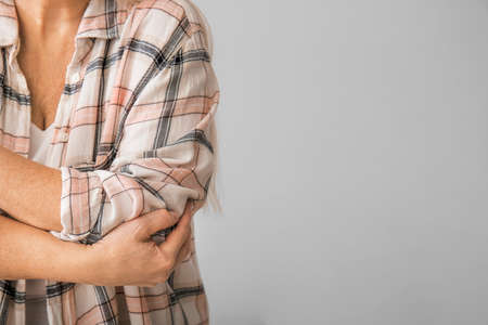 Senior woman suffering from Parkinson syndrome on gray background, closeupの写真素材