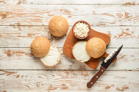 Fresh buns with tasty cream cheese on tableの写真素材