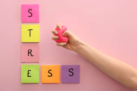Hand squeezing stress ball on color backgroundの写真素材