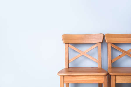 Wooden chairs near light wallの写真素材