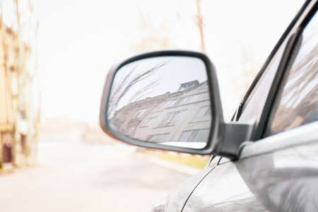 Side mirror of modern car on city street