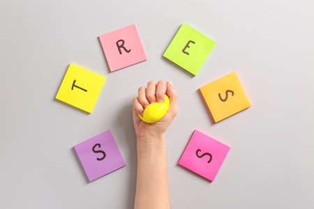 Hand squeezing stress ball on light backgroundの写真素材