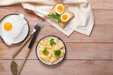 Different tasty dishes with eggs on wooden tableの写真素材