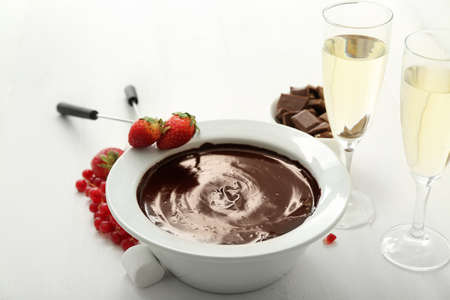 Bowl with tasty chocolate fondue, berries and marshmallow on tableの写真素材