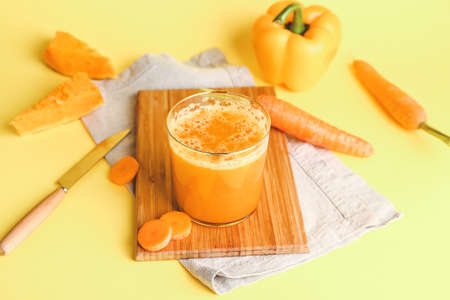 Glass of fresh vegetable juice on color backgroundの写真素材