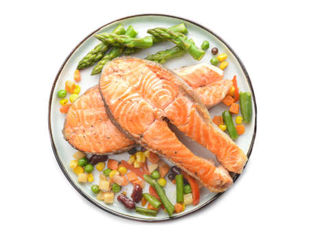 Plate with fried salmon and vegetables on white backgroundの写真素材