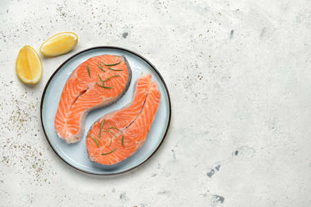 Plate with raw salmon steaks on tableの写真素材