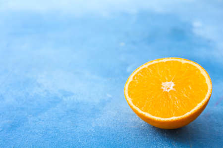 Half of sweet tasty orange on color background