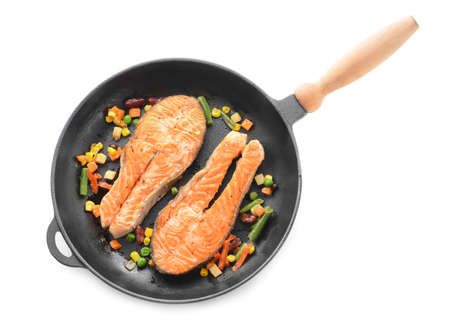 Pan with fried salmon and vegetables on white backgroundの写真素材