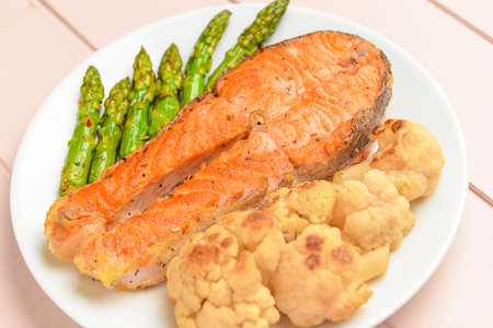 Plate with fried salmon and vegetables on table, closeupの写真素材