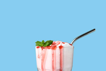 Glass of tasty milkshake on color background