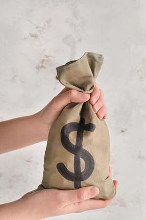 Female hands holding bag with money on white backgroundの写真素材
